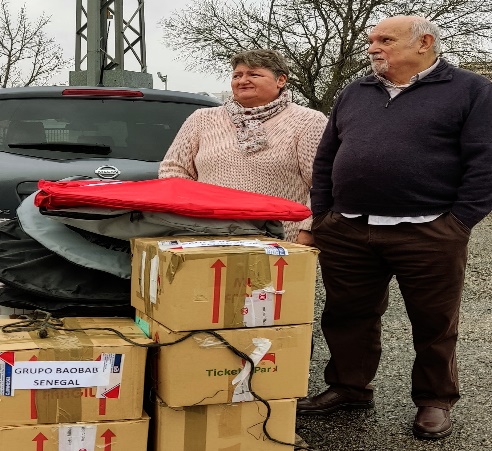 Dos voluntarios junto a cajas de material para Baobab Senegal